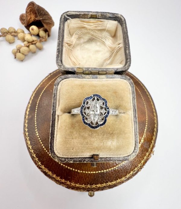 Art Deco Inspired Marquise Diamond and Sapphire Cluster Dress Ring in Platinum, marquise-cut diamond within diamond set intricate open-work design surround and outer border of calibre sapphires. Circa 2000