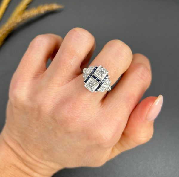 Art Deco Style Sapphire and Diamond Geometric Plaque Ring, two round brilliant cut diamonds in square bezel settings bordered by calibre sapphires in 18ct white gold with diamond stepped shoulders