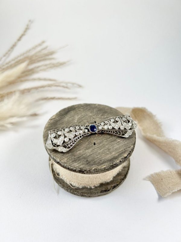 Vintage Antique Art Deco 3.4ct Old Cut Diamond and Sapphire Bow Brooch in Platinum, 1ct old cushion cut sapphire in diamond encrusted platinum decorative pierced framework with original antique velvet-lined fitted box. Circa 1920s