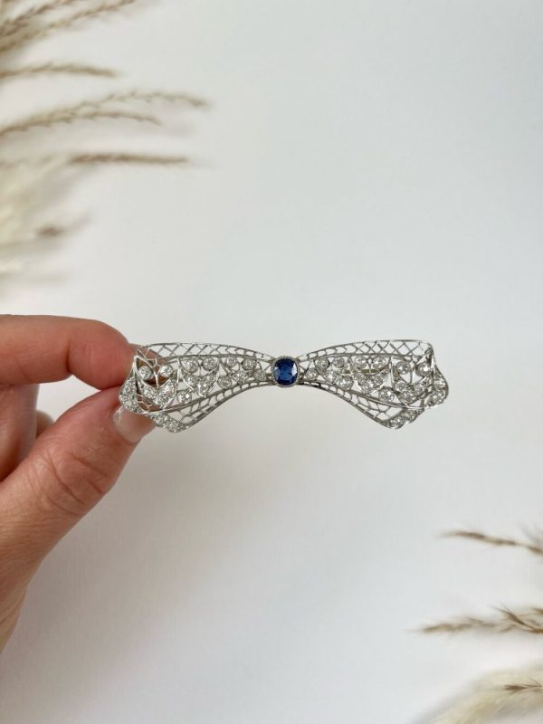 Vintage Antique Art Deco 3.4ct Old Cut Diamond and Sapphire Bow Brooch in Platinum, 1ct old cushion cut sapphire in diamond encrusted platinum decorative pierced framework with original antique velvet-lined fitted box. Circa 1920s