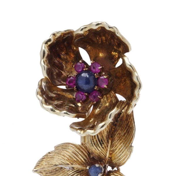 Gold flower brooch with sapphires and rubies.