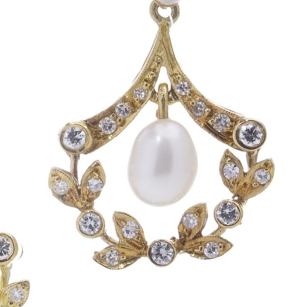 Diamond and pearl drop earrings in gold.