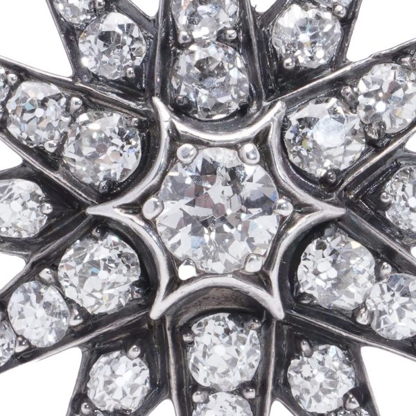 Victorian diamond sunburst star brooch in gold and silver.