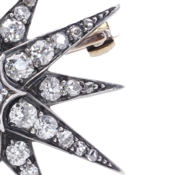 Victorian diamond sunburst star brooch in gold and silver.