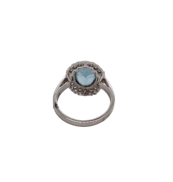 A vintage inspired ring with a 2.10 carat oval aquamarine in the centre surrounded by 0.55 carats of diamonds, rubover set in 18ct white gold.