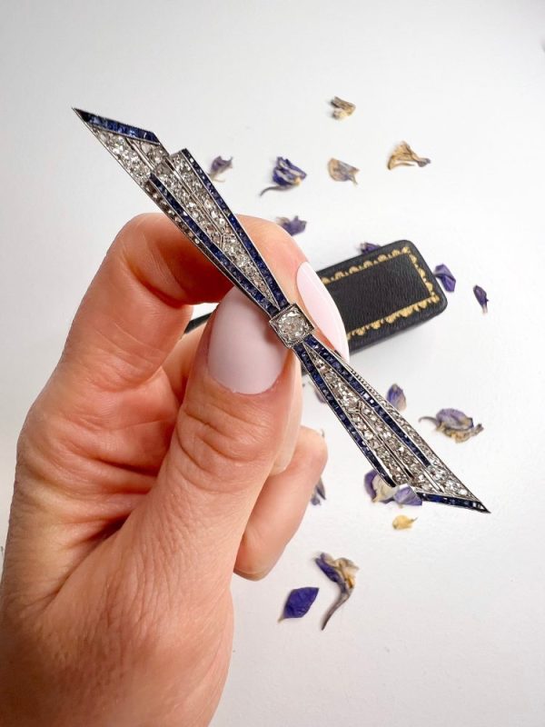 Antique platinum bow brooch, circa 1910, with sapphires and old-cut diamond.