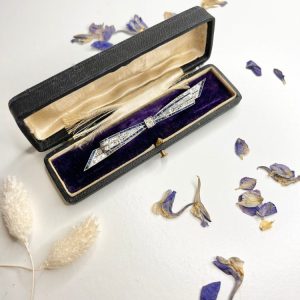 Antique platinum bow brooch, circa 1910, with sapphires and old-cut diamond.