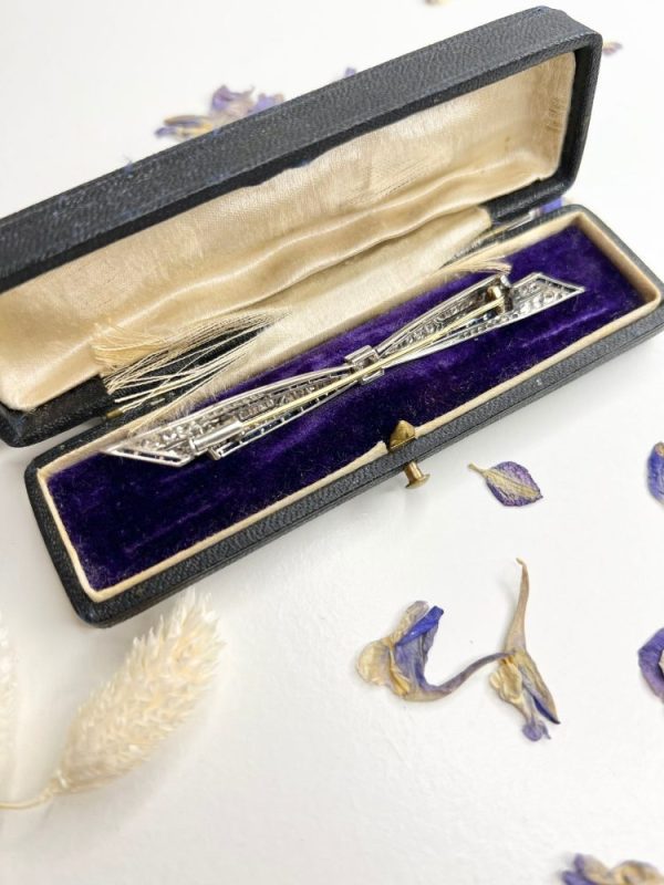Antique platinum bow brooch, circa 1910, with sapphires and old-cut diamond.