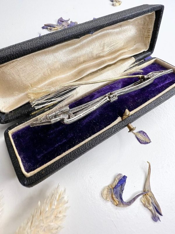 Antique platinum bow brooch, circa 1910, with sapphires and old-cut diamond.
