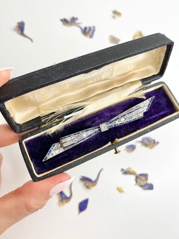 Antique platinum bow brooch, circa 1910, with sapphires and old-cut diamond.