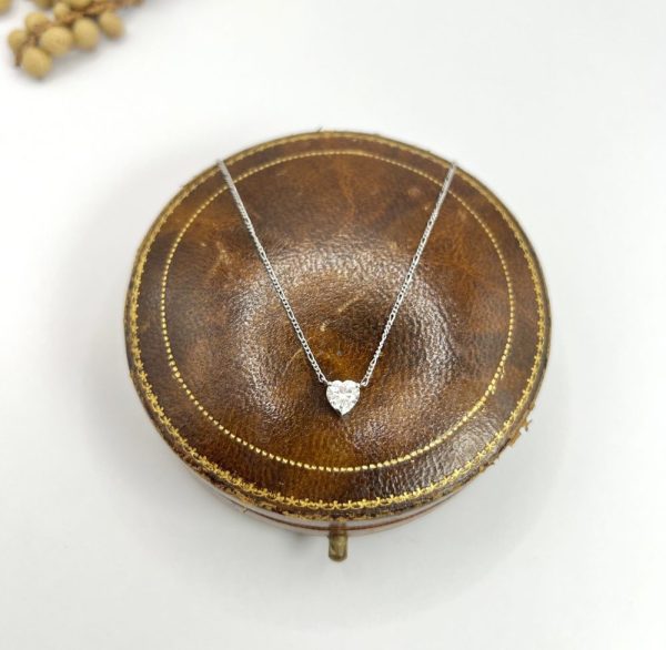 Diamond heart pendant necklace on platinum chain.