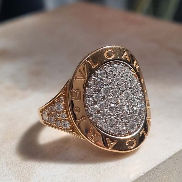Bvlgari Pave Diamond Oval Panel Statement Ring in 18ct Rose Gold, central curved oval panel section pave-set with sparkling diamonds encased within gold border engraved with the iconic BVLGARI BVLGARI