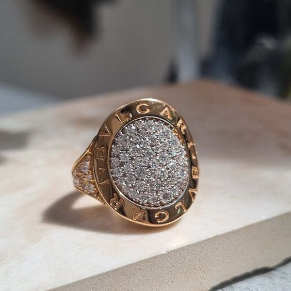 Bvlgari Pave Diamond Oval Panel Statement Ring in 18ct Rose Gold, central curved oval panel section pave-set with sparkling diamonds encased within gold border engraved with the iconic BVLGARI BVLGARI