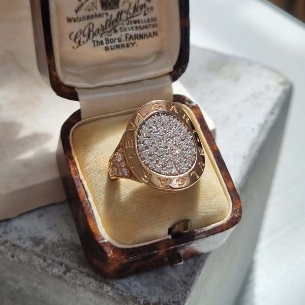 Bvlgari Pave Diamond Oval Panel Statement Ring in 18ct Rose Gold, central curved oval panel section pave-set with sparkling diamonds encased within gold border engraved with the iconic BVLGARI BVLGARI