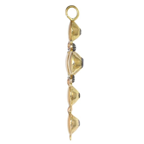 Baroque diamond cross pendant in gold.