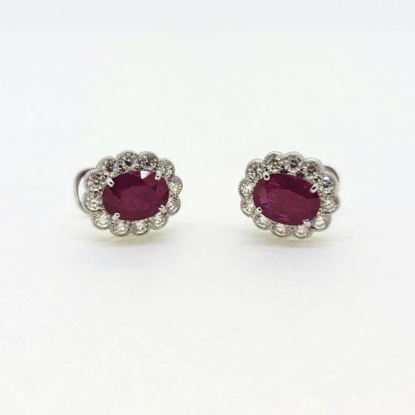 2.88ct Oval Ruby and Diamond Floral Cluster Stud Earrings 18ct White Gold, 2.88cts oval red rubies surrounded by 0.80cts round brilliant-cut diamonds in flower cluster design