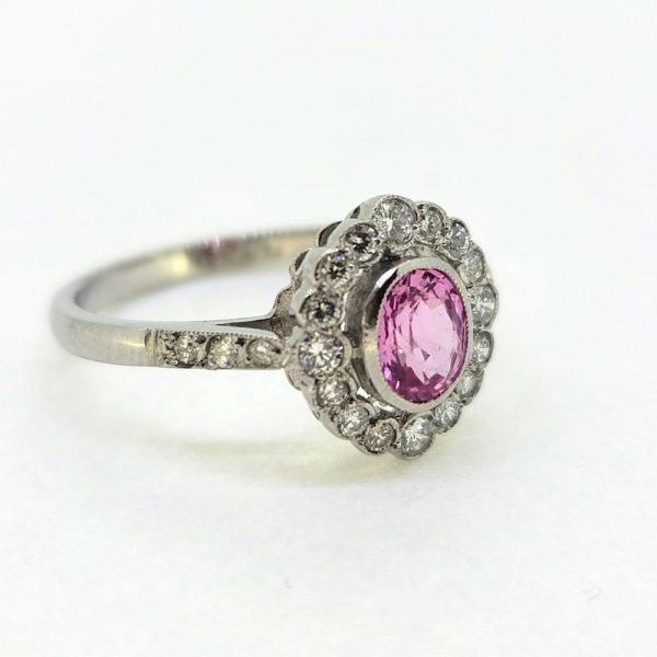 0.80ct Pink Sapphire and Diamond Cluster Engagement Ring in Platinum, 0.80ct oval pink sapphire surrounded by 0.40cts sparkling diamonds in timeless floral cluster design