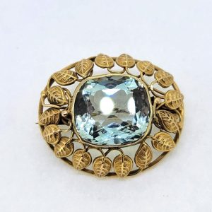 Victorian Antique Aquamarine and Gold Brooch, cushion-shaped sea blue aquamarine is set within detailed yellow gold surround of gold leaves