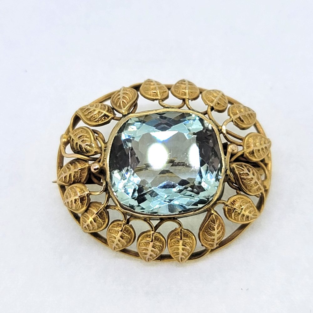 Victorian Antique Aquamarine and Gold Brooch, cushion-shaped sea blue aquamarine is set within detailed yellow gold surround of gold leaves
