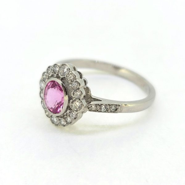 0.80ct Pink Sapphire and Diamond Cluster Engagement Ring in Platinum, 0.80ct oval pink sapphire surrounded by 0.40cts sparkling diamonds in timeless floral cluster design