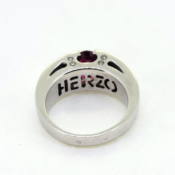 Romain Herzo 1ct Ruby and Diamond Ring, 1ct oval red ruby flanked by three row split diamond shoulders in 18ct white gold