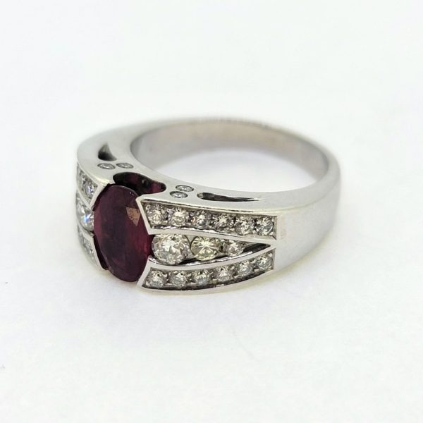 Romain Herzo 1ct Ruby and Diamond Ring, 1ct oval red ruby flanked by three row split diamond shoulders in 18ct white gold