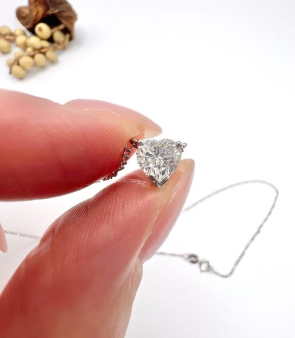 Diamond heart pendant necklace on platinum chain.