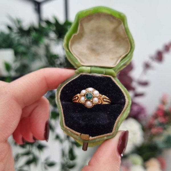 Georgian Antique Emerald and Pearl Cluster Ring, emerald surrounded by pearls in timeless floral cluster design in yellow gold accented with scrolled shoulders and gold granule detailing and locket compartment to reverse
