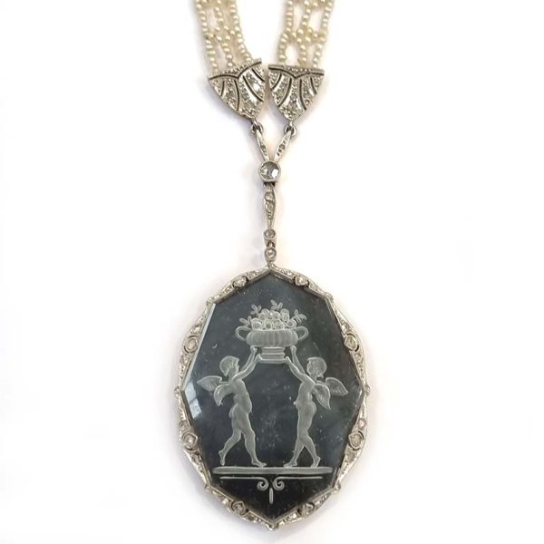 Antique Onyx and Rock Crystal Intaglio Pendant on Seed Pearl Sautoir Necklace, long geometric strung seed pearls suspends oval black onyx and rock crystal intaglio pendant featuring two winged cherubs holding aloft  flowers in an urn