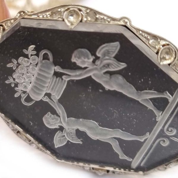 Antique Onyx and Rock Crystal Intaglio Pendant on Seed Pearl Sautoir Necklace, long geometric strung seed pearls suspends oval black onyx and rock crystal intaglio pendant featuring two winged cherubs holding aloft  flowers in an urn