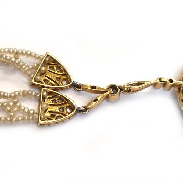 Antique Onyx and Rock Crystal Intaglio Pendant on Seed Pearl Sautoir Necklace, long geometric strung seed pearls suspends oval black onyx and rock crystal intaglio pendant featuring two winged cherubs holding aloft  flowers in an urn