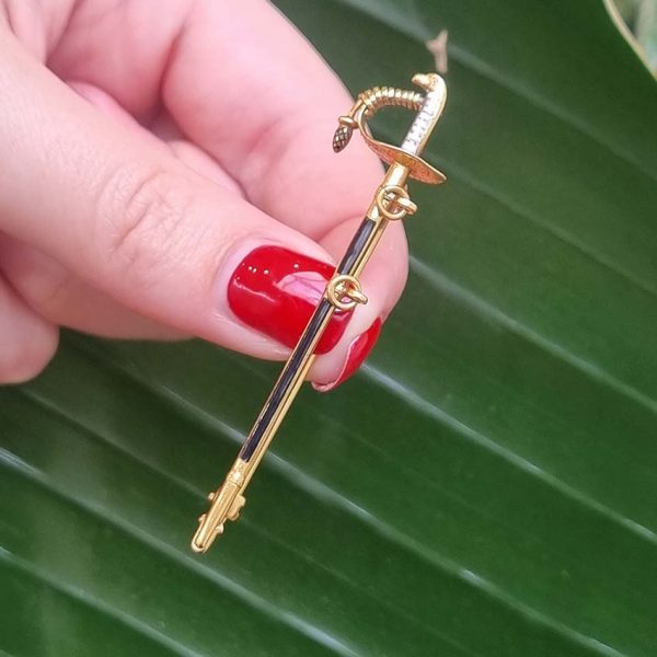 Vintage Gold and Enamel Sword Pin Brooch, yellow gold sword detailed with black enamel along the scabbard sheath and white enamel to the hilt with acorn/pineapple pendant drop