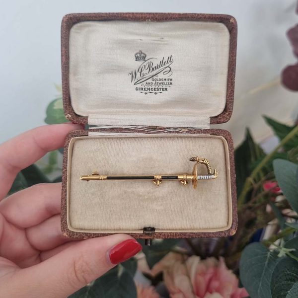 Vintage Gold and Enamel Sword Pin Brooch, yellow gold sword detailed with black enamel along the scabbard sheath and white enamel to the hilt with acorn/pineapple pendant drop