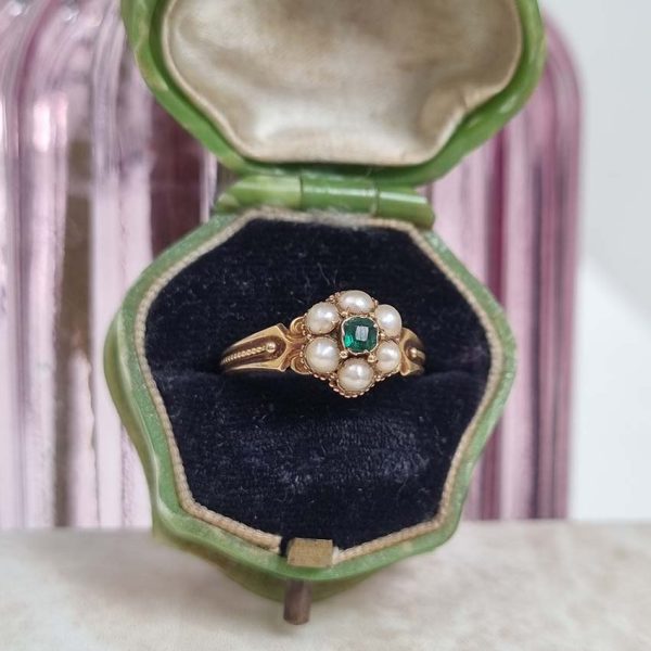 Georgian Antique Emerald and Pearl Cluster Ring, emerald surrounded by pearls in timeless floral cluster design in yellow gold accented with scrolled shoulders and gold granule detailing and locket compartment to reverse