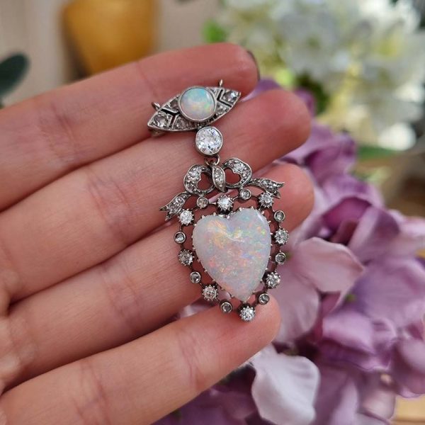 Edwardian Belle Epoque Antique Heart Opal and Diamond Pendant Brooch, heart shaped cabochon opal surrounded by diamonds topped with diamond bow suspended from diamond navette with central round cabochon opal with central old mine-cut diamond link connecting the two parts. Presented in fitted antique box