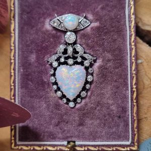 Edwardian Belle Epoque Antique Heart Opal and Diamond Pendant Brooch, heart shaped cabochon opal surrounded by diamonds topped with diamond bow suspended from diamond navette with central round cabochon opal with central old mine-cut diamond link connecting the two parts. Presented in fitted antique box