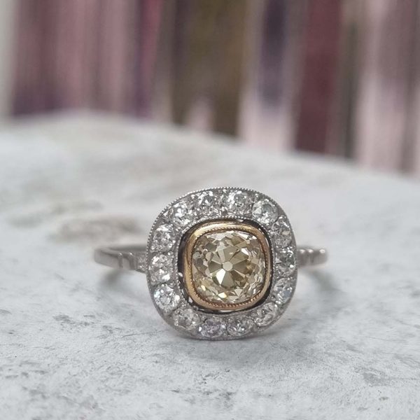 Antique 1.17ct Old Mine Cut Yellow Diamond Cluster Engagement Ring in Platinum, 1.17ct old mine-cut yellow diamond surrounded by halo of white diamonds