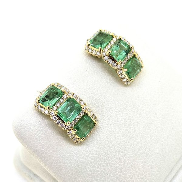 3.50ct Emerald and Diamond Cluster Half Hoop Huggie Earrings in 18ct Yellow Gold, three emerald-cut emeralds set horizontally in a line surrounded by sparkling diamonds