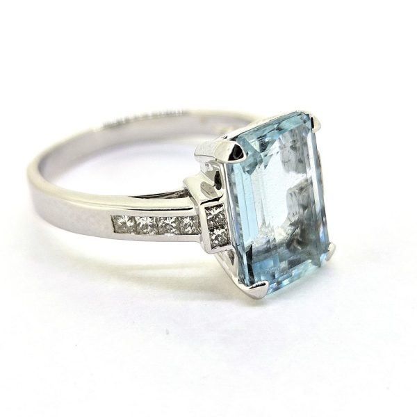 3ct Aquamarine and Princess Cut Diamond Engagement Ring, 3.02ct emerald-cut aquamarine flanked by square princess-cut diamonds in 18ct white gold