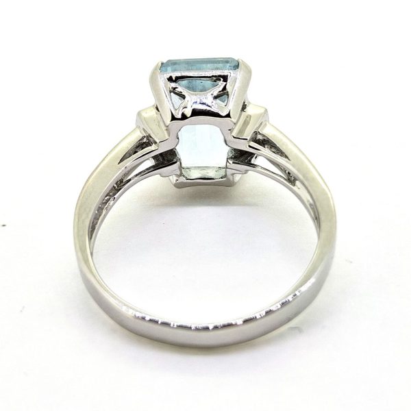 3ct Aquamarine and Princess Cut Diamond Engagement Ring, 3.02ct emerald-cut aquamarine flanked by square princess-cut diamonds in 18ct white gold