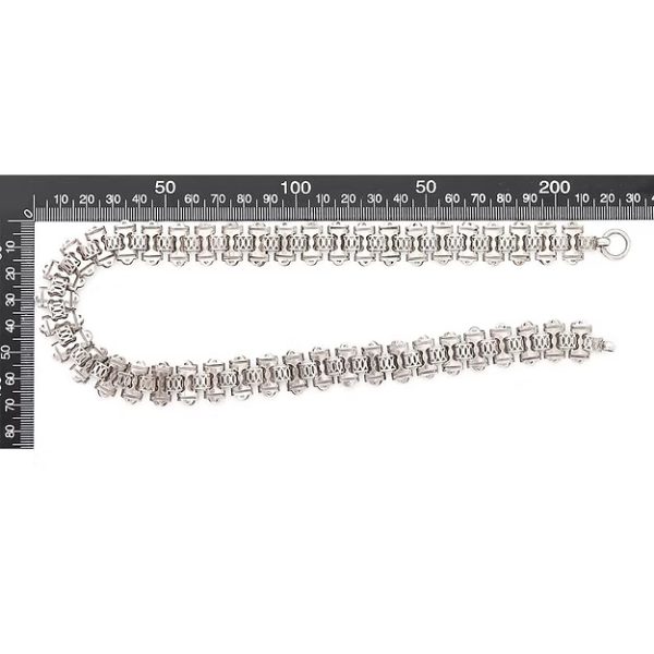 Victorian silver collar necklace featuring engraved flat links, foliate connectors, and heart-shaped details, circa 1880.