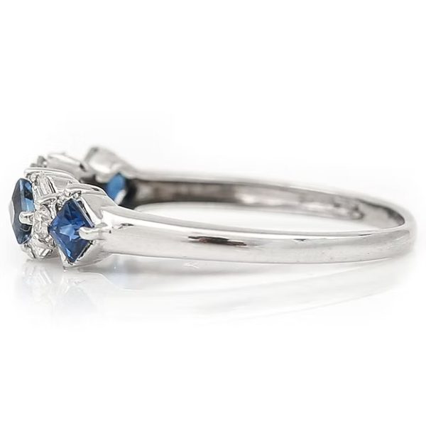 Contemporary 18ct white gold half eternity ring with square-cut blue sapphires and baguette and brilliant-cut diamonds in a geometric design.