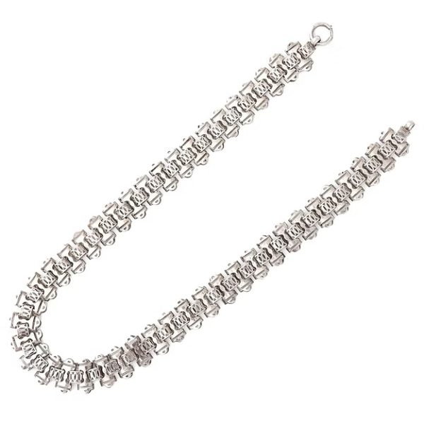 Victorian silver collar necklace featuring engraved flat links, foliate connectors, and heart-shaped details, circa 1880.