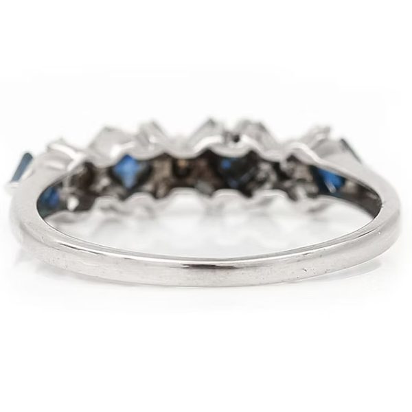 Contemporary 18ct white gold half eternity ring with square-cut blue sapphires and baguette and brilliant-cut diamonds in a geometric design.