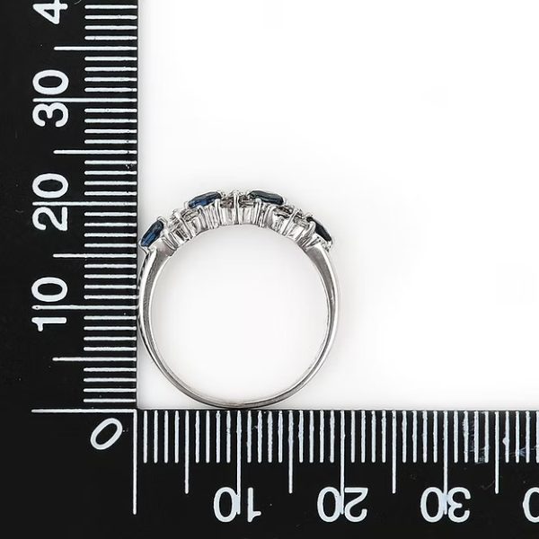 Contemporary 18ct white gold half eternity ring with square-cut blue sapphires and baguette and brilliant-cut diamonds in a geometric design.