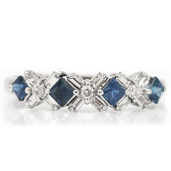Contemporary 18ct white gold half eternity ring with square-cut blue sapphires and baguette and brilliant-cut diamonds in a geometric design.