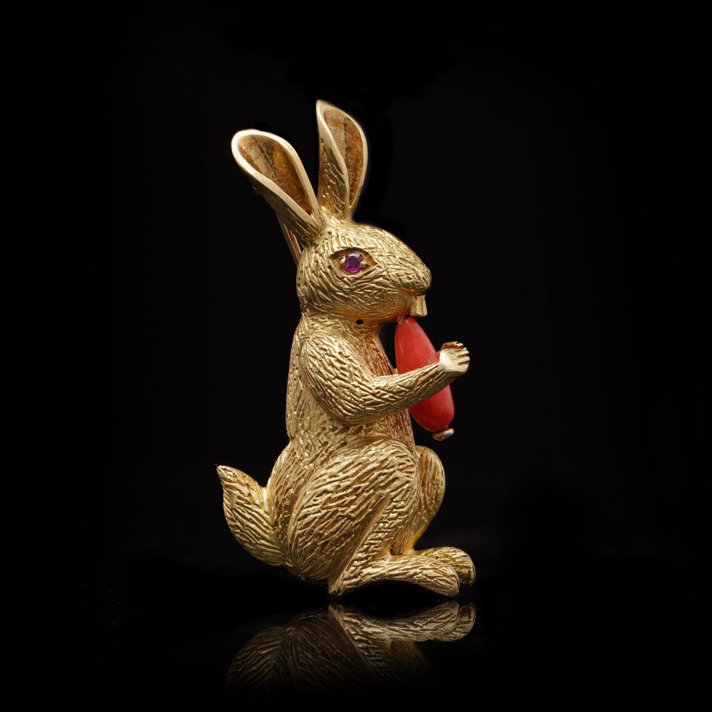 Gold bunny brooch with coral carrot and ruby eye.