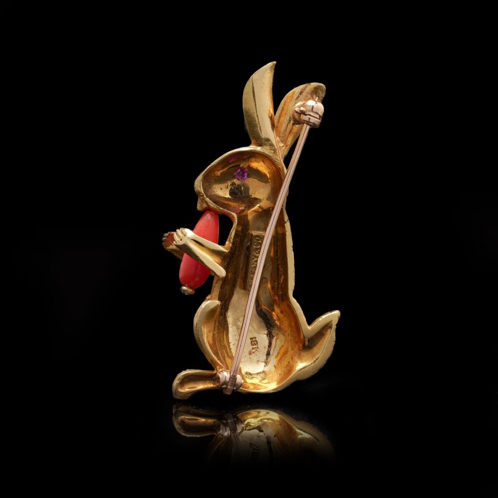 Gold bunny brooch with coral carrot and ruby eye.