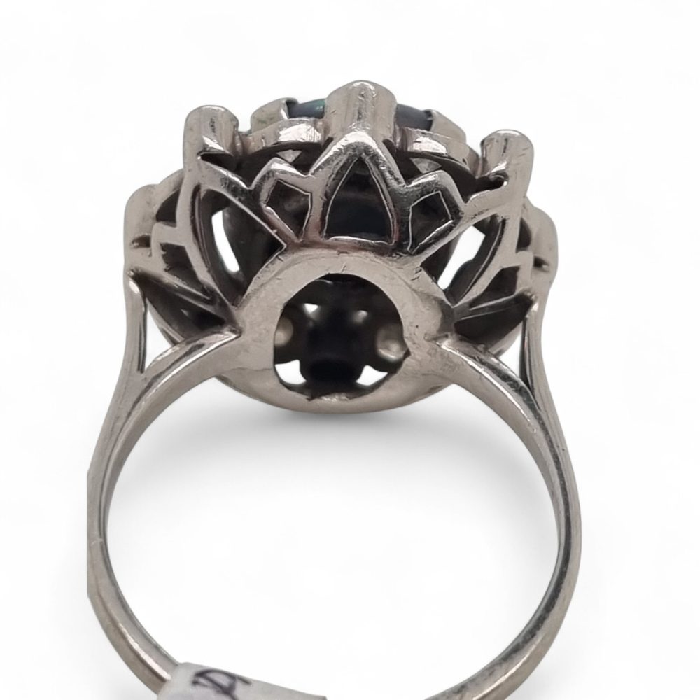 Vintage black opal and diamond cluster ring in platinum, featuring a circular black opal cabochon surrounded by 16 round-cut diamonds.