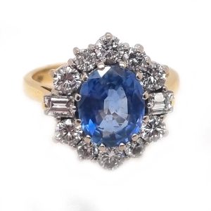 Vintage Cornflower Blue Sapphire and Diamond Cluster Engagement Ring, 2.88ct cornflower blue sapphire surrounded by 0.90cts brilliant cut diamonds with baguette diamonds to the shoulders in 18ct white gold to 18ct yellow gold band
